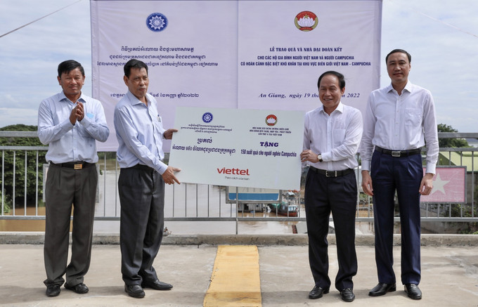 Đoàn Việt Nam trao bảng tượng trưng tặng 150 suất quà cho người nghèo Campuchia. Ảnh: Thanh Sang - TTXVN Bàn giao nhà Đại đoàn kết và tặng quà cho người dân vùng biên giới Việt Nam - Campuchia ảnh 3