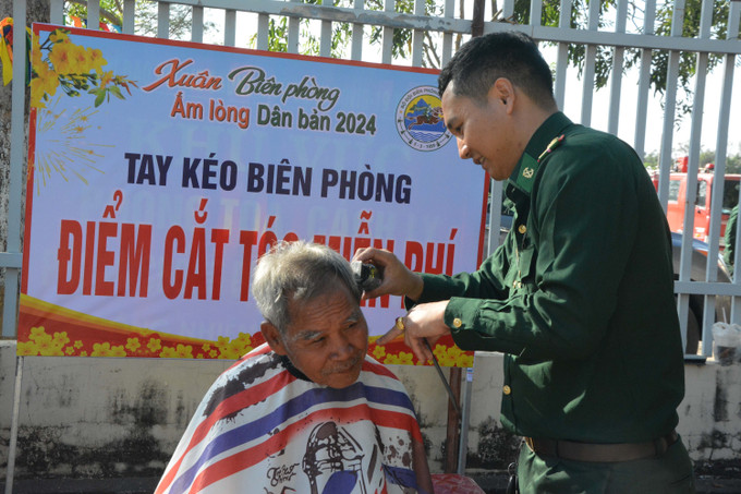 Bộ đội biên phòng cắt tóc cho nhân dân biên giới. Ảnh: Tuấn Anh – TTXVN Mang Tết đến vùng biên Đắk Lắk ảnh 3