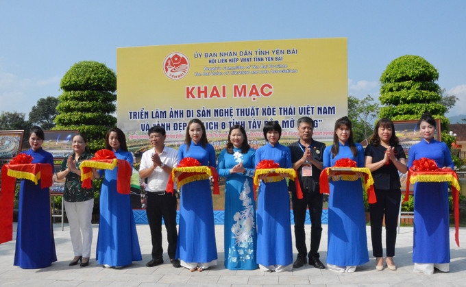 Các đại biểu cắt băng khai mạc Triển lãm. Ảnh - Tuấn Anh-TTXVN Khai mạc triển lãm ảnh “Di sản Nghệ thuật Xòe Thái Việt Nam” và “Ảnh đẹp Du lịch 8 tỉnh Tây Bắc” mở rộng năm 2022 ảnh 1