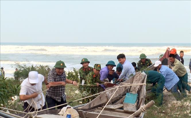 Cán bộ, chiến sĩ Bộ chỉ huy Quân sự tỉnh Thừa Thiên – Huế giúp người dân xã Phong Hải, huyện Phong Điền đưa tàu thuyền vào vị trí an toàn để tránh trú bão số 13. Ảnh: Đỗ Trưởng - TTXVN Ứng phó với bão số 13: các tỉnh Thừa Thiên - Huế, Quảng Nam, Đà Nẵng thực hiện nghiêm túc các phương án phòng, chống bão ảnh 1