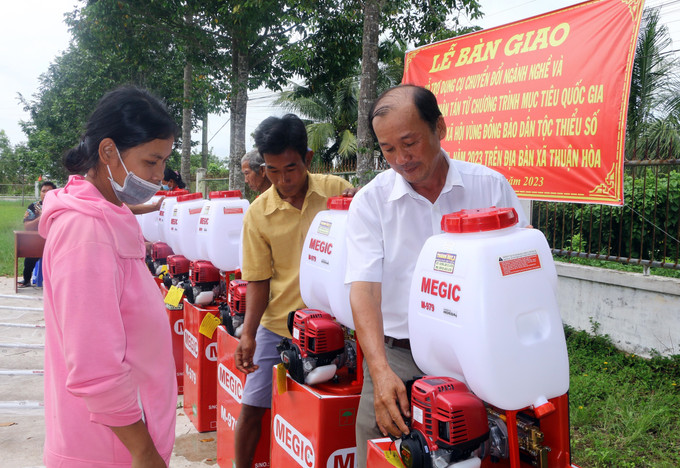 Cán bộ huyện Châu Thành (Sóc Trăng) hướng dẫn sử dụng máy phun thuốc bảo vệ thực vật cho đồng bào Khmer. Ảnh: Tuấn Phi - TTXVN Hỗ trợ dụng cụ chuyển đổi ngành nghề cho đồng bào Khmer ảnh 1