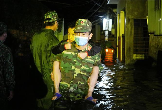 Bộ đội cùng lực lượng chức năng đưa trẻ em từ các nhà dân bị ngập sâu đến nơi an toàn. Ảnh: Phạm Cường-TTXVN 77 năm thành lập Quân đội: Bộ Chỉ huy quân sự tỉnh Phú Yên đồng hành cùng người dân vượt qua bão, lũ ảnh 2