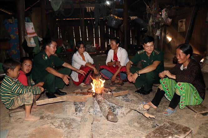 Cán bộ, chiến sĩ Đồn Biên phòng Mường Lạn tuyên truyền, hướng dẫn người dân cháp hành chủ trương, chính sách pháp luật. Ảnh: Hữu Quyết - TTXVN Điểm tựa giúp đồng bào vùng biên Sơn La ổn định cuộc sống ảnh 1
