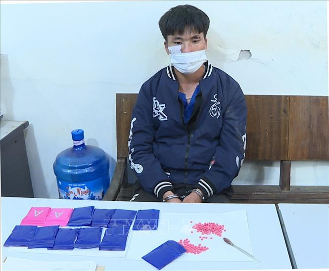Đối tượng cùng tang vật. Ảnh: TTXVN phát. Sơn La: Bắt giữ đối tượng mua bán trái phép hơn 2.300 viên ma túy tổng hợp ảnh 2