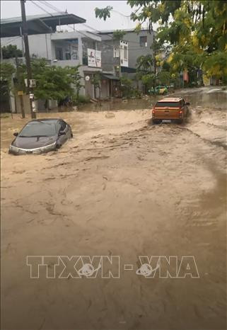 Đường phố ngập úng gây khó khăn cho các phương tiện giao thông. Ảnh: TTXVN Điện Biên: Mưa lớn trong đêm gây ngập úng cục bộ, nhiều đoạn đường hóa sông sâu ảnh 3