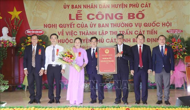 Đại diện Đảng bộ, UBND xã Cát Tiến nhận Nghị quyết của Ủy ban thường vụ Quốc hội về việc thành lập thị trấn Cát Tiến. Ảnh: Phạm Kha – TTXVN Bình Định tổ chức lễ công bố Nghị quyết về thành lập thị trấn Cát Tiến ảnh 1