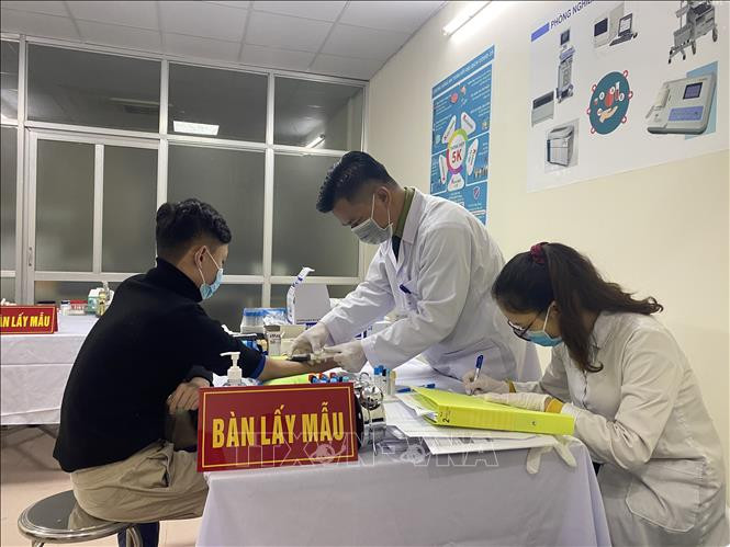 Các tình nguyện viên được kiểm tra sức khoẻ trước khi tiêm mũi vaccine ngừa COVID-19 Nano Covax nhóm liều 50mcg. Ảnh: Diệp Trương - TTXVN Tiếp tục thử nghiệm vaccine ngừa COVID-19 Nano Covax nhóm liều 50mcg ảnh 1