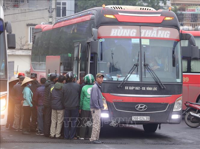 Người dân không đeo khẩu trang hoặc đeo không đúng cách, không giữ khoảng cách tại bến xe Giáp Bát. Ảnh: Hoàng Hiếu - TTXVN Bộ Y tế sẽ hướng dẫn thống nhất thực hiện quy định phòng dịch COVID-19 với người dân về quê đón Tết ảnh 2