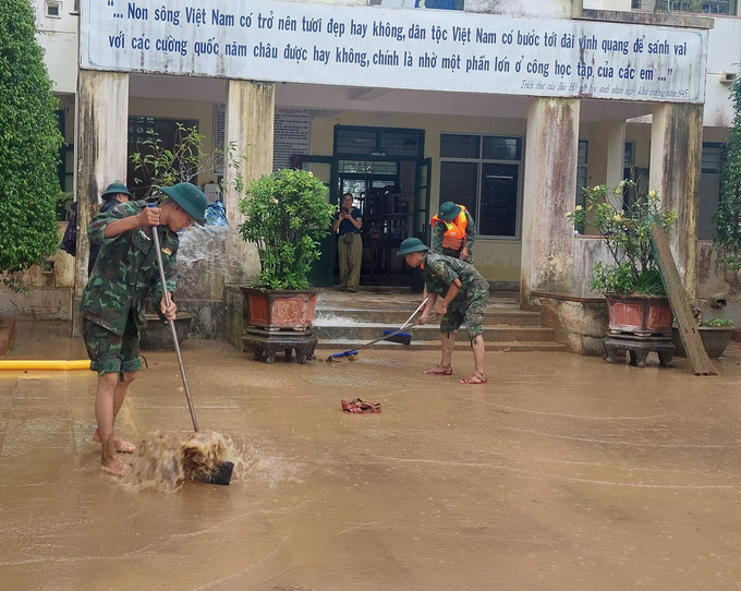 Lực lượng bộ đội hỗ trợ dọn bùn đất tại Trường Tiểu học và Trung học Cơ sở Cam Tuyền, huyện Cam Lộ (Quảng Trị). Ảnh: TTXVN phát Quảng Trị khẩn trương khắc phục hậu quả, tìm kiếm người mất tích do mưa lũ ảnh 2