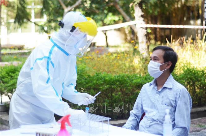 Thành viên Ban in sao đề thi lấy mẫu xét nghiệm virus SARS-CoV-2 nhằm đảm bảo an toàn cho kỳ thi. Ảnh: Văn Dũng - TTXVN Kỳ thi tốt nghiệp THPT năm 2020 (đợt 2): Đà Nẵng tổ chức điểm thi riêng cho các thí sinh F1, F2 ảnh 1