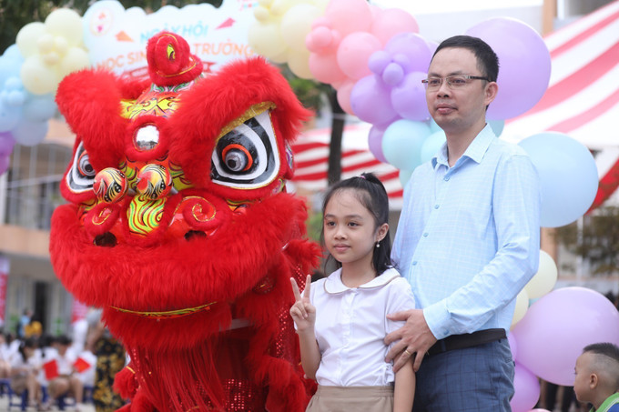 Cùng ba đến trường dự khai giảng năm học mới. Ảnh: Minh Quyết - TTXVN Thầy - trò cả nước rộn ràng bước vào năm học mới 2023 - 2024 ảnh 4