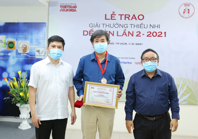 Nhà thơ Trần Đăng Khoa (phải) và ông Lê Xuân Thành trao giải cho nhà văn Bình Ca. Ảnh: TTXVN Giải thưởng Thiếu nhi Dế Mèn lần 2: Các tác phẩm đoạt giải đều là dấu ấn đậm nét trong sáng tác cho thiếu nhi ảnh 1