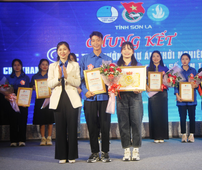 Bí thư tỉnh Đoàn Sơn La Cầm Thị Huyền Trang trao giải Nhất cho tác giải đạt giải. Ảnh: Phan Quân - TTXVN Cuộc thi ý tưởng, dự án khởi nghiệp trong thanh niên, sinh viên dân tộc ảnh 1