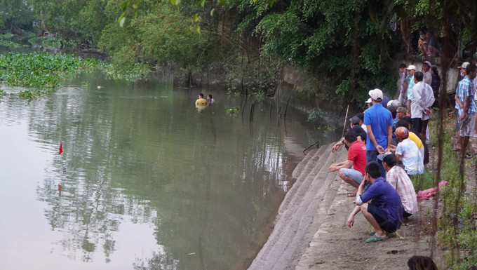 Lực lượng chức năng tìm kiếm thi thể cháu bé bị đuối nước. Ảnh: Nhựt An - TTXVN Đồng Tháp: Ba chị em ruột tử vong khi tắm sông ảnh 1
