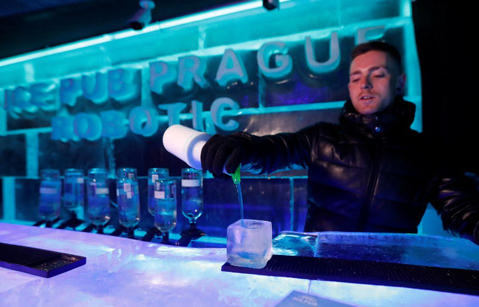 Một nhân viên pha chế chuẩn bị đồ uống trong ly làm bằng băng bên trong Ice Pub ở Prague, Cộng hòa Séc, ngày 19/7/2022. Ảnh: Reuters Quán rượu băng - dịch vụ mới giúp du khách tránh nóng ở CH Séc ảnh 1