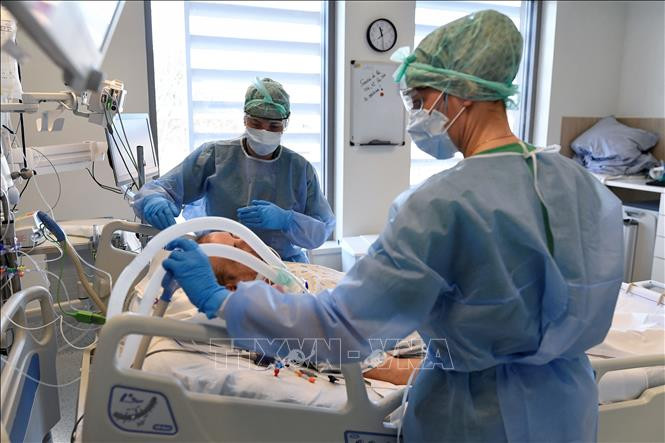 Nhân viên y tế điều trị cho bệnh nhân COVID-19 tại bệnh viện ở Brussels, Bỉ, ngày 6/4/2021. Ảnh: AFP/ TTXVN Mắc COVID-19 có thể gây tổn thương thần kinh lâu dài ảnh 1
