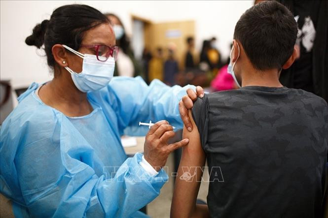 Nhân viên y tế tiêm vaccine phòng COVID-19 cho học sinh tại Kathmandu, Nepal, ngày 12/1/2022. Ảnh: THX/ TTXVN WHO cảnh báo Omicron đặc biệt nguy hiểm với người chưa tiêm vaccine ảnh 1