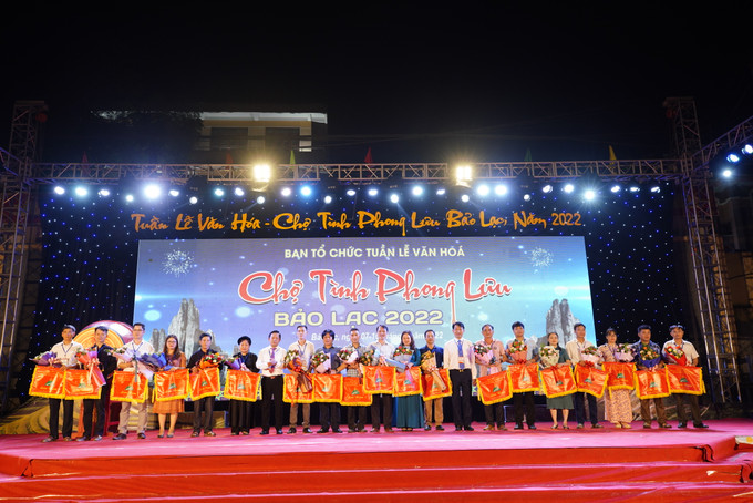 Lãnh đạo huyện Bảo Lạc trao cờ lưu niệm cho các đơn vị tham gia Tuần lễ Văn hóa. Ảnh: Ngọc Đức - TTXVN Tuần lễ Văn hóa - Chợ tình phong lưu Bảo Lạc, tỉnh Cao Bằng ảnh 2