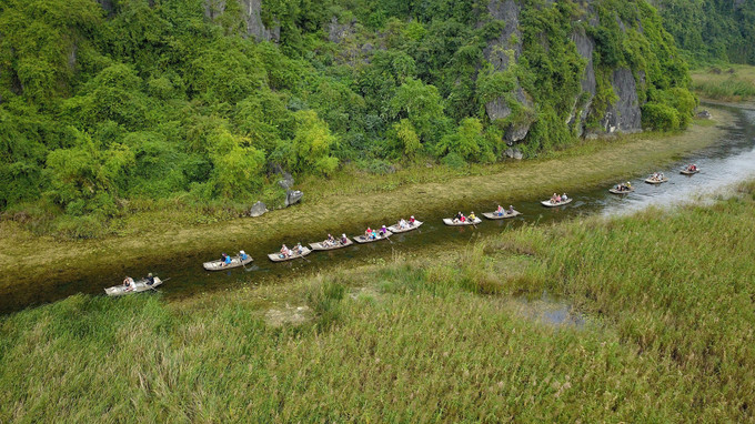 Du khách trong và ngoài nước tham quan khu bảo tồn thiên nhiên đất ngập nước Vân Long bằng thuyền. Ảnh: Minh Đức - TTXVN Ninh Bình: Phát triển du lịch gắn với bảo tồn hệ sinh thái và bảo vệ môi trường ảnh 1