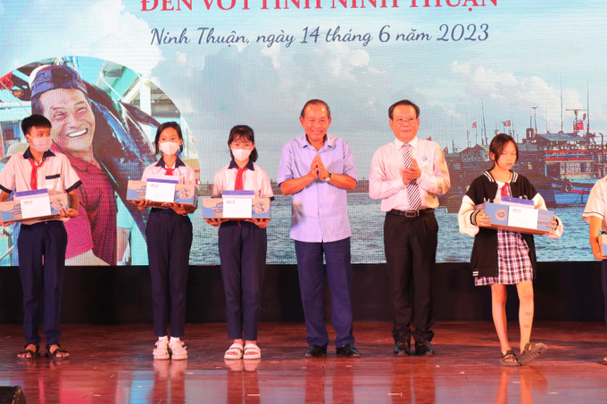 Nguyên Ủy viên Bộ Chính trị, nguyên Phó Thủ tướng Thường trực Chính phủ Trương Hòa Bình cùng đại diện Ban tổ chức tặng học bổng cho các em học sinh trong Chương trình “Cùng ngư dân thắp sáng đèn trên biển”. Ảnh: Nguyễn Thành – TTXVN Chương trình “Cùng ngư dân thắp sáng đèn trên biển” đến với Ninh Thuận ảnh 3