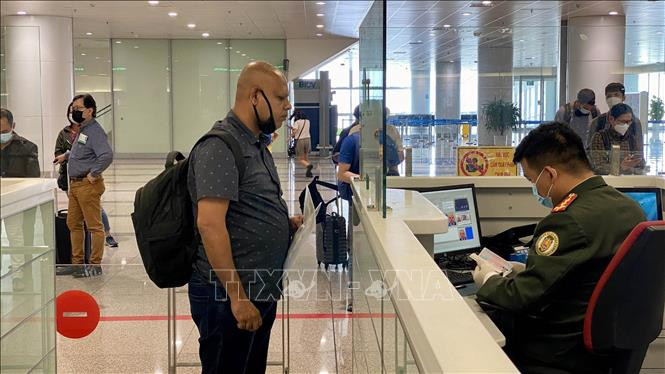 Làm thủ tục nhập cảnh vào Việt Nam tại Cảng hàng không quốc tế Nội Bài trong ngày đầu mở cửa đón khách quốc tế. Ảnh: TTXVN Miễn thị thực nhập cảnh Việt Nam cho công dân 13 nước ảnh 1