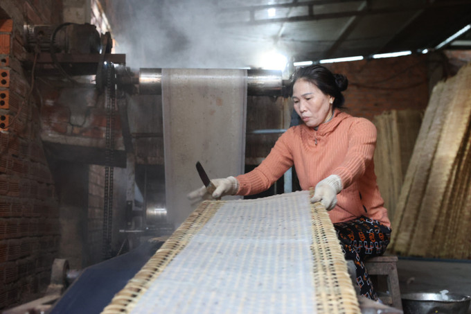 Ngày nay, nhiều gia đình đầu tư hệ thống máy móc, dây truyền tráng bánh nên tăng năng suất lên gấp nhiều lần so với làm thủ công. Ảnh: Tuấn Anh – TTXVN Làng nghề bánh tráng Hòa Nhơn "chạy" đơn hàng Tết ảnh 2