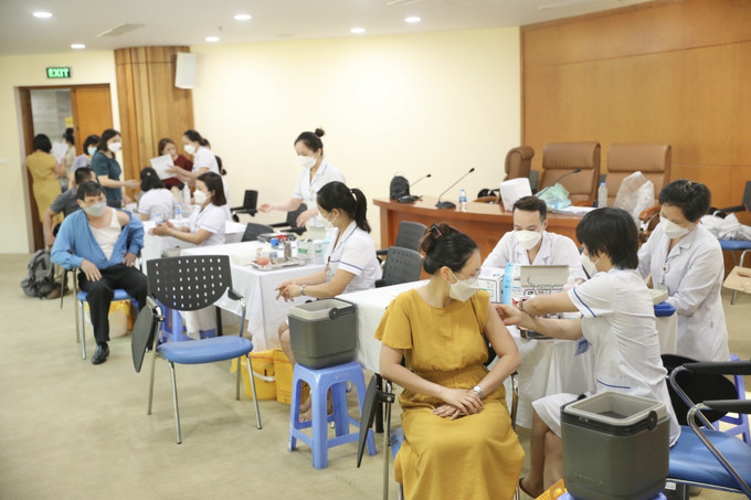 Cán bộ, công chức, viên chức và người lao động hưởng ứng tiêm vaccine mũi nhắc lại trong ngày phát động. Ảnh: Minh Quyết - TTXVN Phát động tiêm vaccine phòng COVID-19 mũi 3 và mũi 4 cho công nhân, viên chức, lao động ảnh 2