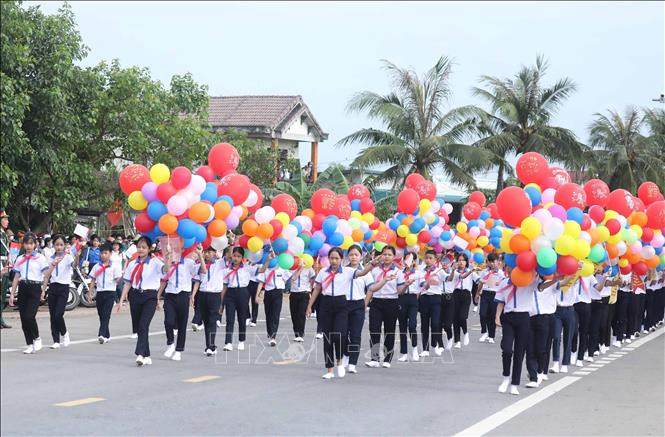 Các em học sinh trong lễ diễu hành. Ảnh: Thống Nhất - TTXVN Chủ tịch nước Nguyễn Xuân Phúc dự Lễ thượng cờ Thống nhất non sông tại Di tích Đôi bờ Hiền Lương - Bến Hải ảnh 7