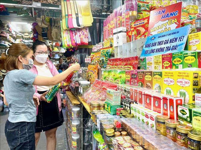Du khách lựa chọn nón lá làm quà kỉ niệm khi đến chợ Đông Ba. Ảnh: Mai Trang - TTXVN Chợ Đông Ba - điểm đến du lịch truyền thống hấp dẫn ảnh 2