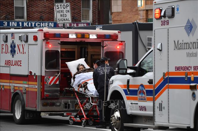Nhân viên y tế chuyển bệnh nhân COVID-19 tới trung tâm y tế tại New York, Mỹ. Ảnh: AFP/ TTXVN Mỹ cảnh báo người chưa tiêm phòng có nguy cơ nhập viện cao gấp gần 30 lần ảnh 1