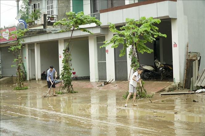 Sau khi nước rút, người dân tiến hành thu gom rác thải và quét dọn vỉa hè, lòng đường. Ảnh: Xuân Tư – TTXVN Điện Biên: Mưa lớn trong đêm gây ngập úng cục bộ, nhiều đoạn đường hóa sông sâu ảnh 4