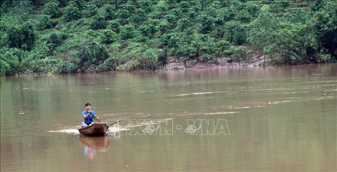 Người dân ở thôn 3, xã Đăk Pne chèo xuồng qua vi trí cây cầu bị cuốn trôi để lấy lương thực, thực phẩm. Ảnh: Cao Nguyên - TTXVN Khắc phục hậu quả bão số 9: Kon Tum mở đường tiếp cận vùng bị lũ cô lập ảnh 1