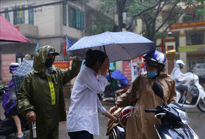 Lực lượng công an giúp đỡ thí sinh vào điểm thi Trường THCS Hà Huy Tập (quận Hai Bà Trưng). Ảnh: Hoàng Hiếu - TTXVN Kỳ thi tuyển sinh lớp 10 tại Hà Nội: Đoàn kết làm nên thành công của Kỳ thi “đặc biệt” ảnh 4