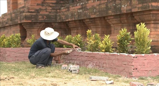 Sau khi báo chí phản ánh, đơn vị thi công đã tiến hành đập bỏ bồn hoa xunh quanh chân tháp. Ảnh: TTTXVN Dự án xây dựng, tu bổ di tích Tháp Bánh Ít (Bình Định): Tạm dừng các công việc liên quan đến sân trên các tháp ảnh 4