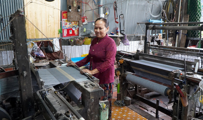 Bà Nguyễn Thị Mèn ngụ xã Long Khánh A, huyện Hồng Ngự (Đồng Tháp) có hơn 40 năm theo nghề dệt choàng. Ảnh: Nhựt An - TTXVN Nghề dệt choàng - Di sản Văn hóa phi vật thể quốc gia ảnh 2