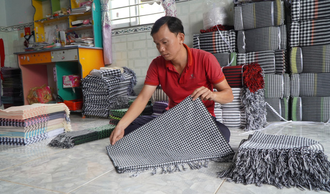 Anh Phạm Thanh An trú tại xã Long Khánh A, huyện Hồng Ngự xếp những chiếc khăn choàng, chuẩn bị mang đi tiêu thụ. Ảnh: Nhựt An - TTXVN Nghề dệt choàng - Di sản Văn hóa phi vật thể quốc gia ảnh 5