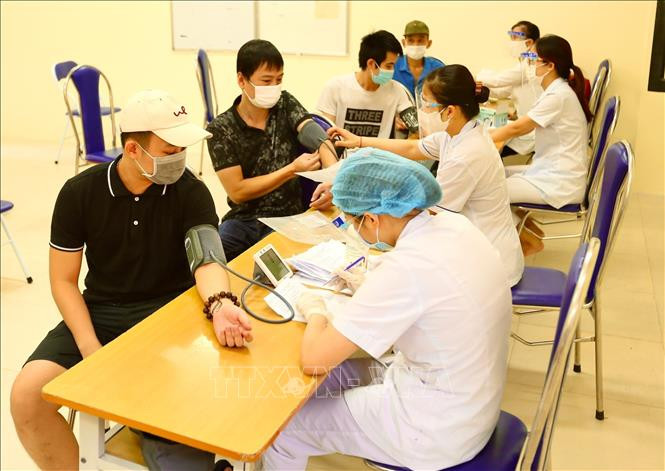 Khám sàng lọc trước tiêm cho người dân phường Bạch Mai(Hai Bà Trưng) sáng 9/9 tại điểm tiêm Trường THPT Thăng Long. Ảnh: Hoàng Hiếu - TTXVN Không đo huyết áp tất cả người tiêm vaccine COVID-19 ảnh 1