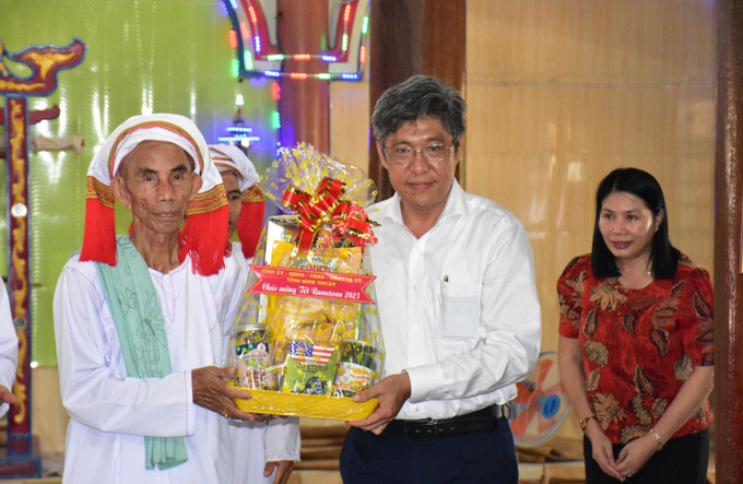 Ông Nguyễn Minh, Phó Chủ tịch UBND tỉnh Bình Thuận, trao quà cho các vị sư cả đang thực hiện tháng Ramadan tại chùa. Ảnh: Hồng Hiếu- TTXVN Lãnh đạo tỉnh Bình Thuận thăm, chúc Tết Ramưwan của đồng bào Chăm Bà Ni ảnh 1