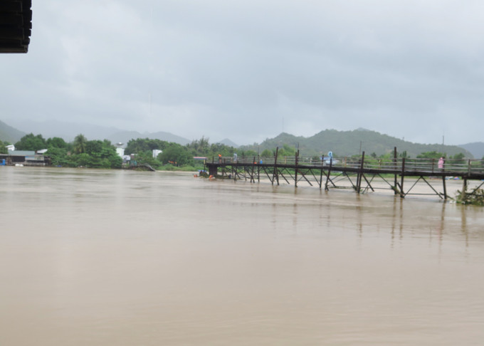 Nước lớn cuốn trôi 40m của Cầu gỗ Phước Kiểng (xã Vĩnh Ngọc, thành phố Nha Trang), khiến việc đi lại qua khu vực này bị ảnh hưởng. Ảnh: Đặng Tuấn - TTXVN Nhiều khu dân cư tại Khánh Hòa ngập sâu trong đêm ảnh 5