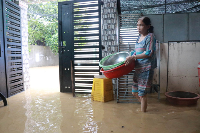 Người dân xã Vĩnh Thanh, Nha Trang, dọn dẹp nhà chờ nước rút. Ảnh: Đặng Tuấn - TTXVN Nhiều khu dân cư tại Khánh Hòa ngập sâu trong đêm ảnh 3