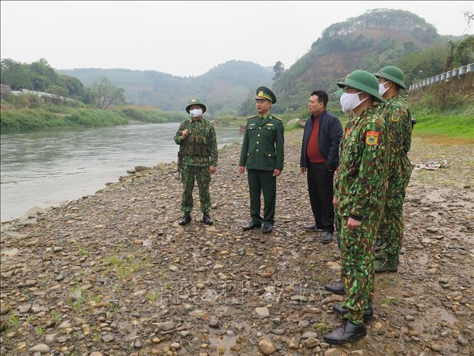 Đại tá Kiều Phi Hùng - Chỉ huy phó, Tham mưu Trưởng Bộ Chỉ huy Biên Phòng tỉnh Lào Cai trực tiếp đi kiểm tra công tác kiểm soát biên giới (thứ hai từ trái sang). Ảnh: Hồng Ninh - TTXVN Dịch COVID-19: Lào Cai tăng cường kiểm soát, ngăn chặn trường hợp nhập cảnh trái phép qua tuyến biên giới ảnh 3