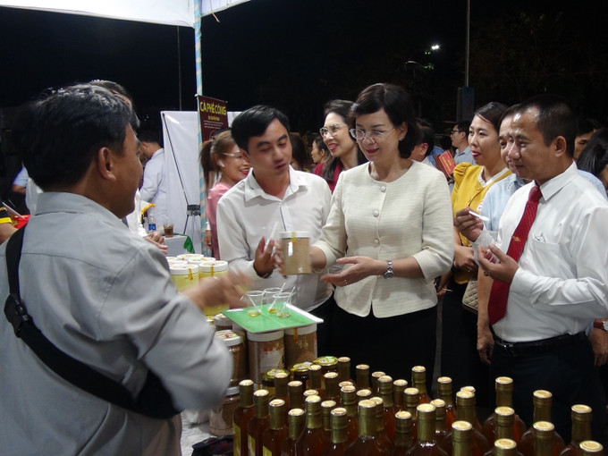 Phó Chủ tịch UBND tỉnh Bình Phước Trần Tuyết Minh cùng các đại biểu tham quan gian hàng trưng bày.Ảnh: K GỬIH -TTXVN Quảng bá văn hóa, du lịch, ẩm thực đặc trưng Đông Nam Bộ ảnh 1