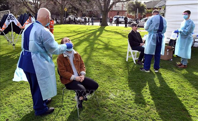 Nhân viên y tế lấy mẫu dịch xét nghiệm COVID-19 cho người dân tại bang Victoria, Australia ngày 2/7/2020. Ảnh: AFP/TTXVN Phát hiện dấu ấn sinh học hỗ trợ đánh giá hiệu quả của vaccine ngừa COVID-19 ảnh 1