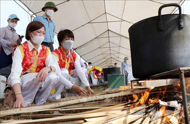 Đội Tam Nông thực hiện phần thi nấu bánh chưng. Ảnh: Trung Kiên - TTXVN. Giỗ Tổ Hùng Vương năm 2022: Hội thi gói, nấu bánh chưng và giã bánh giầy ảnh 6