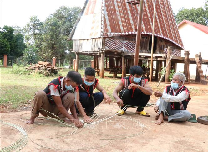 Hướng dẫn thế hệ trẻ đan áo cho cồng, chiêng. Ảnh: Hồng Điệp - TTXVN Gia Lai: Đan áo mới cho cồng, chiêng ảnh 7
