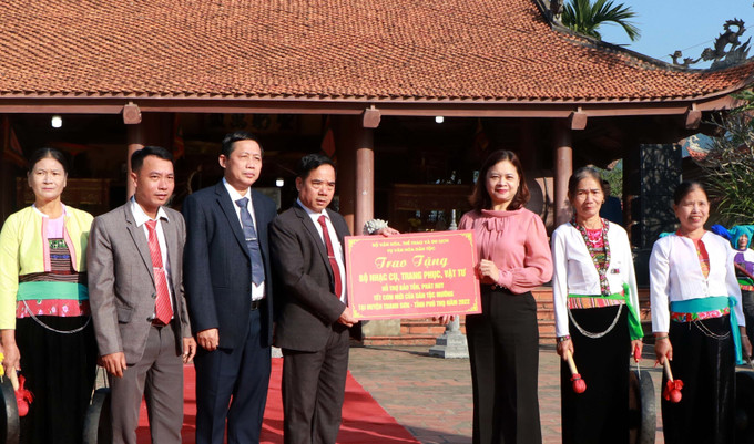 Bà Nguyễn Thị Hải Nhung (thứ 3 từ phải qua), Vụ trưởng Vụ Văn hóa dân tộc - Bộ Văn hóa, Thể thao và Du lịch tặng xã Hương Cần bộ nhạc cụ, trang phục, vật tư hỗ trợ công tác bảo tồn giá trị văn hóa đặc sắc của Tết cơm mới của dân tộc Mường. Ảnh: Trung Kiên - TTXVN Tết cơm mới của người Mường ở Phú Thọ ảnh 9