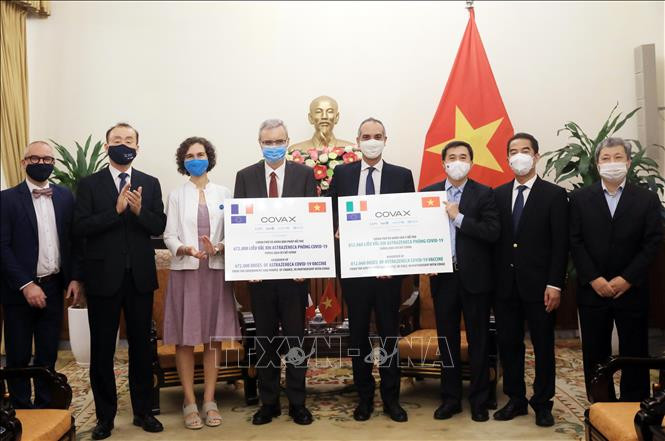 Thứ trưởng Ngoại giao Tô Anh Dũng và Thứ trưởng Bộ Y tế Trần Văn Thuấn tiếp nhận tượng trưng 1,5 triệu liều vaccine AstraZeneca của Pháp và Italy ủng hộ thông qua Cơ chế COVAX. Ảnh: Lâm Khánh - TTXVN Tiếp nhận 1,5 triệu liều vaccine phòng COVID-19 từ Pháp và Italy ảnh 1