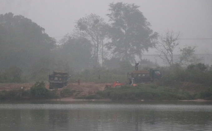 Phương tiện hoạt động lúc rạng sáng tại bãi tập kết cát sỏi trái phép ở bờ sông Thạch Hãn tại khu vực giáp ranh giữa xã Triệu Ái và thị trấn Ái Tử, huyện Triệu Phong, tỉnh Quảng Trị. Ảnh: Nguyên Lý-TTXVN Quảng Trị: Người dân bức xúc về khai thác, tập kết cát trái phép vùng giáp ranh ảnh 3