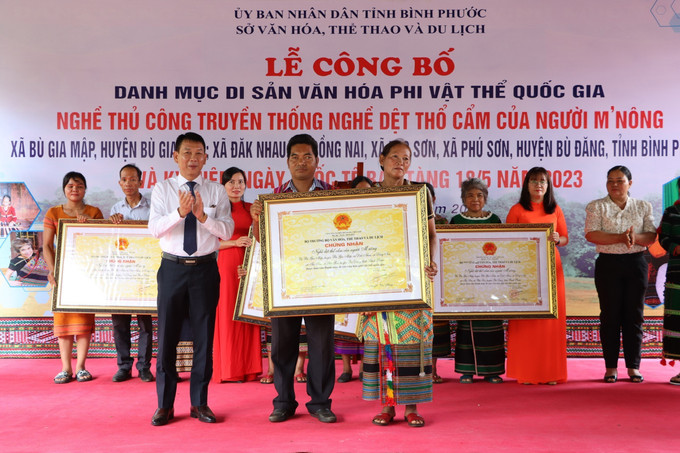 Trao Bằng công nhận dệt thổ cẩm của người M'nông Bình Phước là Di sản phi vật thể quốc gia. Ảnh: TTXVN phát Dệt thổ cẩm của người M'nông Bình Phước được công nhận Di sản Văn hóa phi vật thể quốc gia ảnh 2