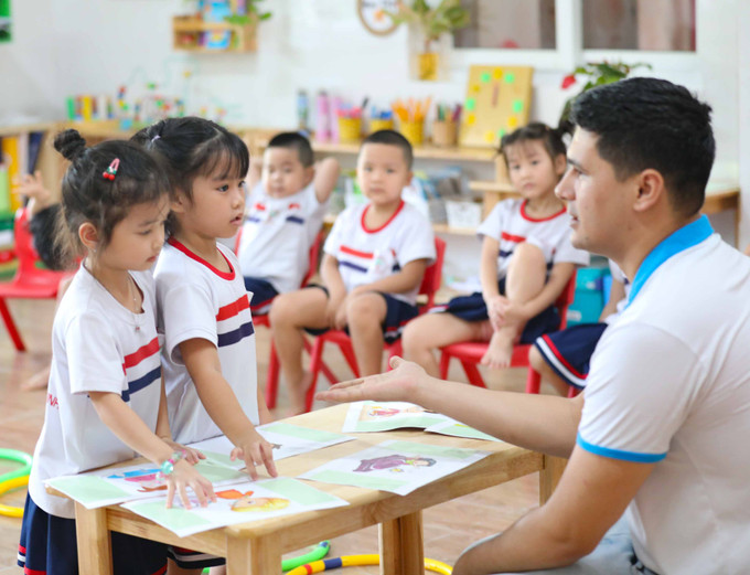 Một tiết học Tiếng Anh cùng giáo viên nước ngoài của học sinh Trường mầm non An Sinh ở thành phố Đồng Hới (Quảng Bình). Ảnh: Thanh Tùng - TTXVN Năm học 2023 - 2024: "Xây dựng trường mầm non hạnh phúc, lấy trẻ em làm trung tâm" ảnh 4